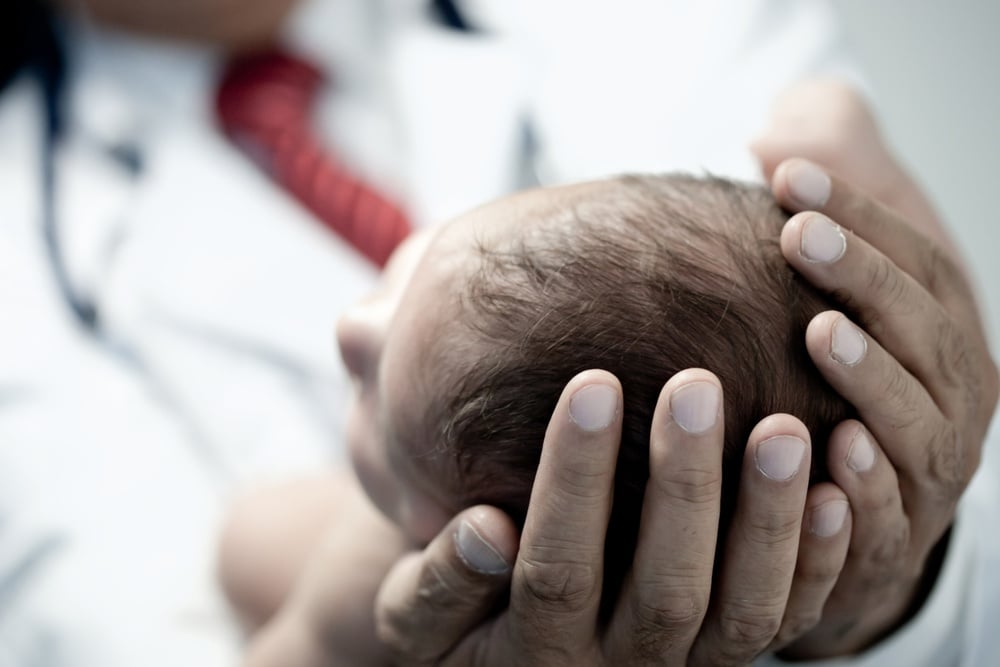 Pediatrician holding a beautiful newborn baby boy.jpeg